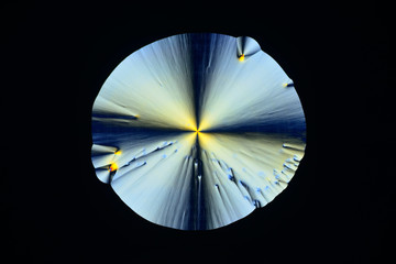 Colorful micro crystals in polarized light. Photo through a microscope.