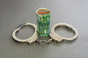 roll Euro money bills (banknotes) of 100 and 50 in handcuffs. Euro bills with handcuffs. Handcuffs...