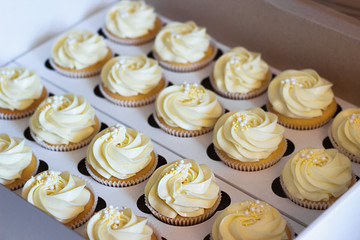 Delicious cupcakes in cardboard box with a hat in the form of a rose