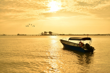 Naklejka premium Fisherman boat with sunset background