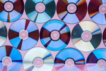 CD DVD compact disc disk dispersion refraction reflection of light colors texture on pink background