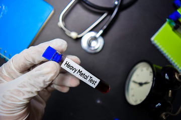 Heavy Metal Test text with blood sample. Top view isolated on black background. Healthcare/Medical...