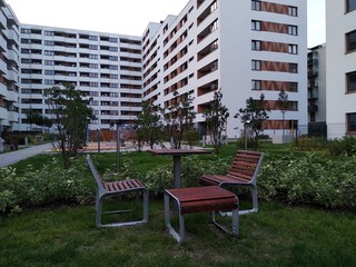 wooden benches and tables in the yard of a modern house for cozy picnics and gatherings with friends and neighbors. sunbeds made of modern materials.