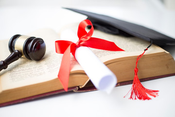 Black graduation cap, degree and gavel