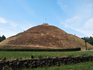 a mound of burnt yellow grass on a blue sky background and white clouds of the air. Hiking, Cycling...