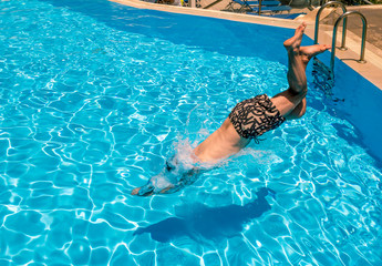 A man dives into the pool at the resort