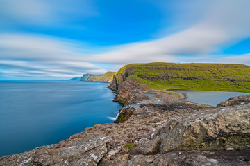 Bosdalafossur waterfall on Vagar island coastline long exposure, Faroe Islands