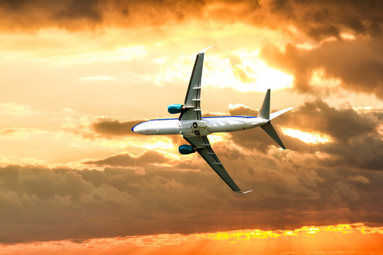 A passenger plane flying in the sky at sunset © toshket
