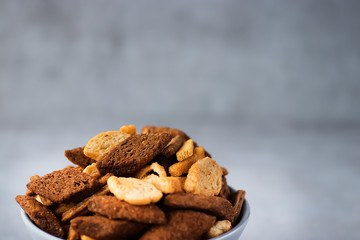 Assorted wheat and rye crackers on a gray background. Salty snack. Snack to beer.