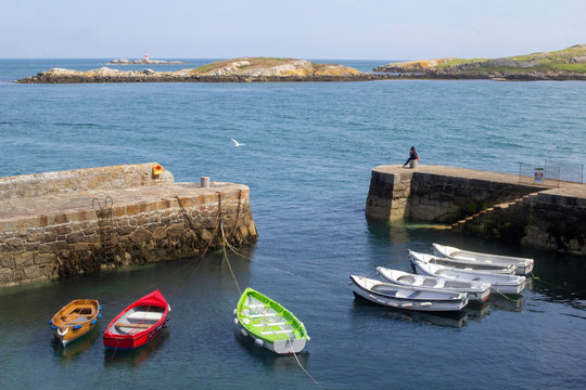Small boats tied up in Coliemore Harbour in Dalkey, Dublin, Ireland. In the middle ages it was the main harbour for the city of Dublin. In the background is Dalkey Island and a small lighthouse..