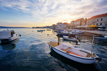 Beautiful sunset landscape. Fishing boat moored on Kastel coast in Dalmatia,Croatia.Old town near Adriatic sea.