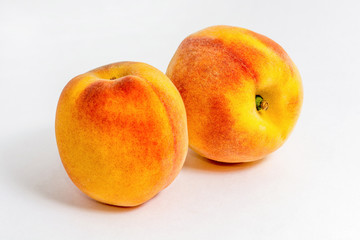 Two juicy peaches. Summer fruits. Harvest on the farm. Delicious igridient for juice. White background.
