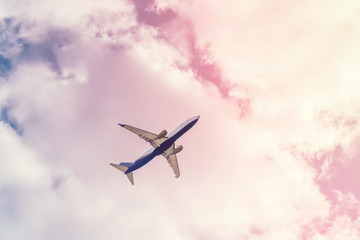 Large passenger plane in the cloudy sky. Bright positive toning. The concept of a summer holiday in the resort. Passenger transportation business. Free space for text.