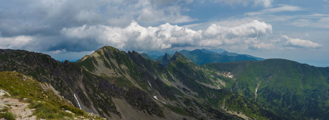 Panoramic view from Banikov peak on Western Tatra mountains or Rohace panorama. Sharp green mountains - ostry rohac, placlive and volovec with hiking trail on ridge. Summer blue sky white clouds. - obrazy, fototapety, plakaty