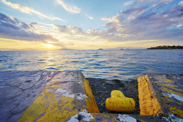 Iron pole for mooring of ships at pier. Beautiful sunset landscape with sea wharf.