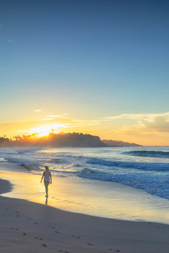 Woman walking on Talalla beach at sunrise, Southern Province, Sri Lanka
