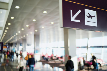 Sign in terminal with an arrow showing direction. Interior of the airport.