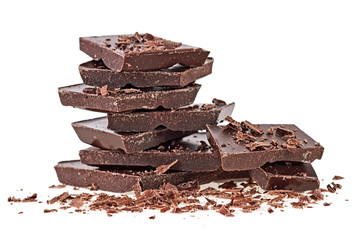 Broken bars of dark chocolate isolated on white background. Selective focus.