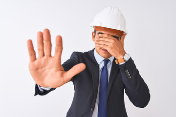Young handsome architect man wearing suit and helmet over isolated white background covering eyes with hands and doing stop gesture with sad and fear expression. Embarrassed and negative concept.