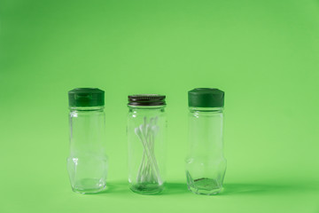 3 Empty glass spice jars on lime green background with blank empty room space