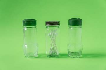 3 Empty glass spice jars on lime green background with blank empty room space