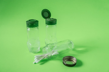 3 Empty glass spice jars on lime green background with blank empty room space