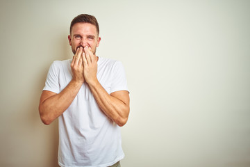 Young handsome man wearing casual white t-shirt over isolated background laughing and embarrassed...