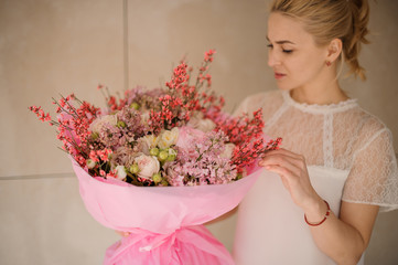 Girl holding a spring bouquet of tender rose color and white flowers