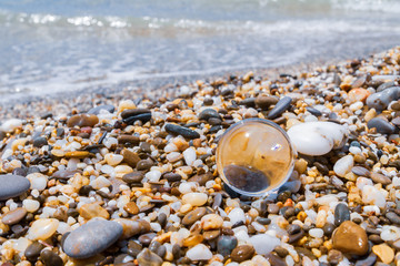 Glass round ball lying on the beach on small stones