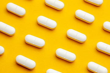 White pills on yellow background.