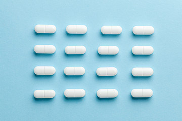 White pills on blue background.