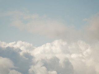 The sky with beautiful cumulus clouds. Restrained pastel colors.