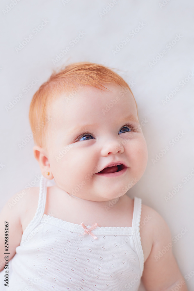 Wall mural portrait of cute smiling baby girl with red hair