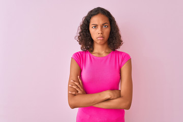 Young brazilian woman wearing t-shirt standing over isolated pink background skeptic and nervous,...