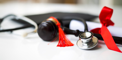 Black graduation cap, degree and stethoscope 