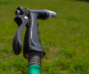 Water hose sprayer attached to a green hose