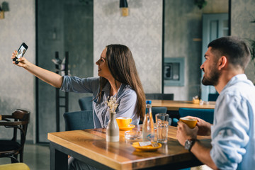 young couple in cafe bar taking picture