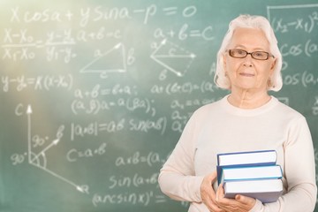 Mature woman teacher with books on background