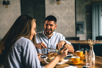 A happy young couple having dinner or breakfast at a fancy restaurant