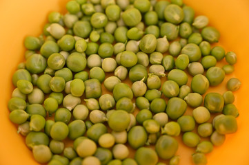Bowl yellow with green peas.