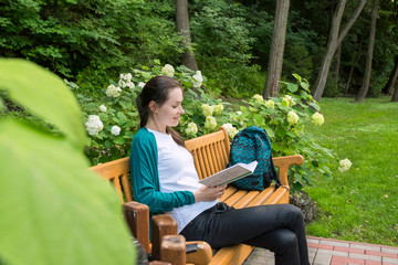 Shot of a college student reading a book in the park.