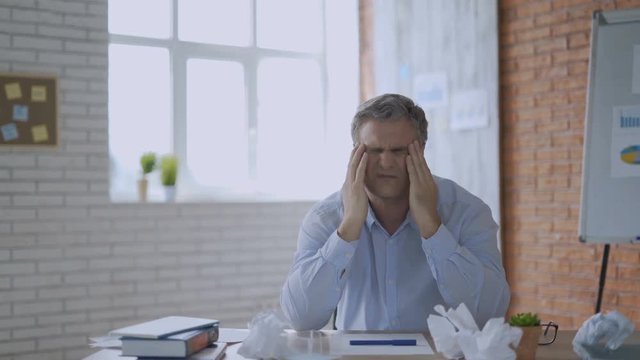 Overworked minded man having headache after working day 4K