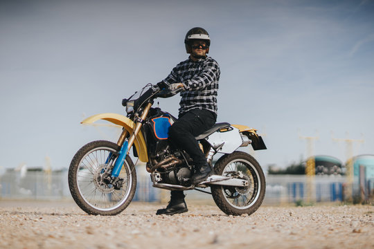 Young man is ridding on off road motorcycle in the desert.