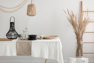 Close-up of table with white linen tablecloth and beige napkin
