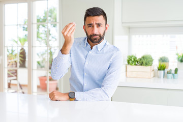 Handsome hispanic business man Doing Italian gesture with hand and fingers confident expression