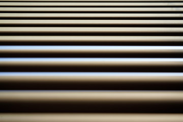 Detail on lines of metallic window blinds, some light reflects on, dust visible, abstract geometric background