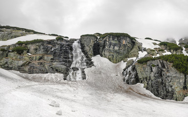 Waterfall 'Skok' in High Tatras, Slovakia, during overcast spring day, dirty snow still covering most of ground © Lubo Ivanko