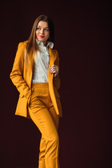 businesswoman posing in a stylish yellow suit against the backgr