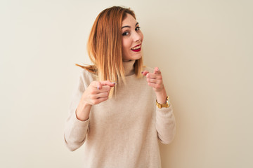 Redhead woman wearing elegant turtleneck sweater standing over isolated white background pointing fingers to camera with happy and funny face. Good energy and vibes.