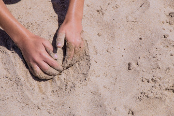 childish hands playing in the sand